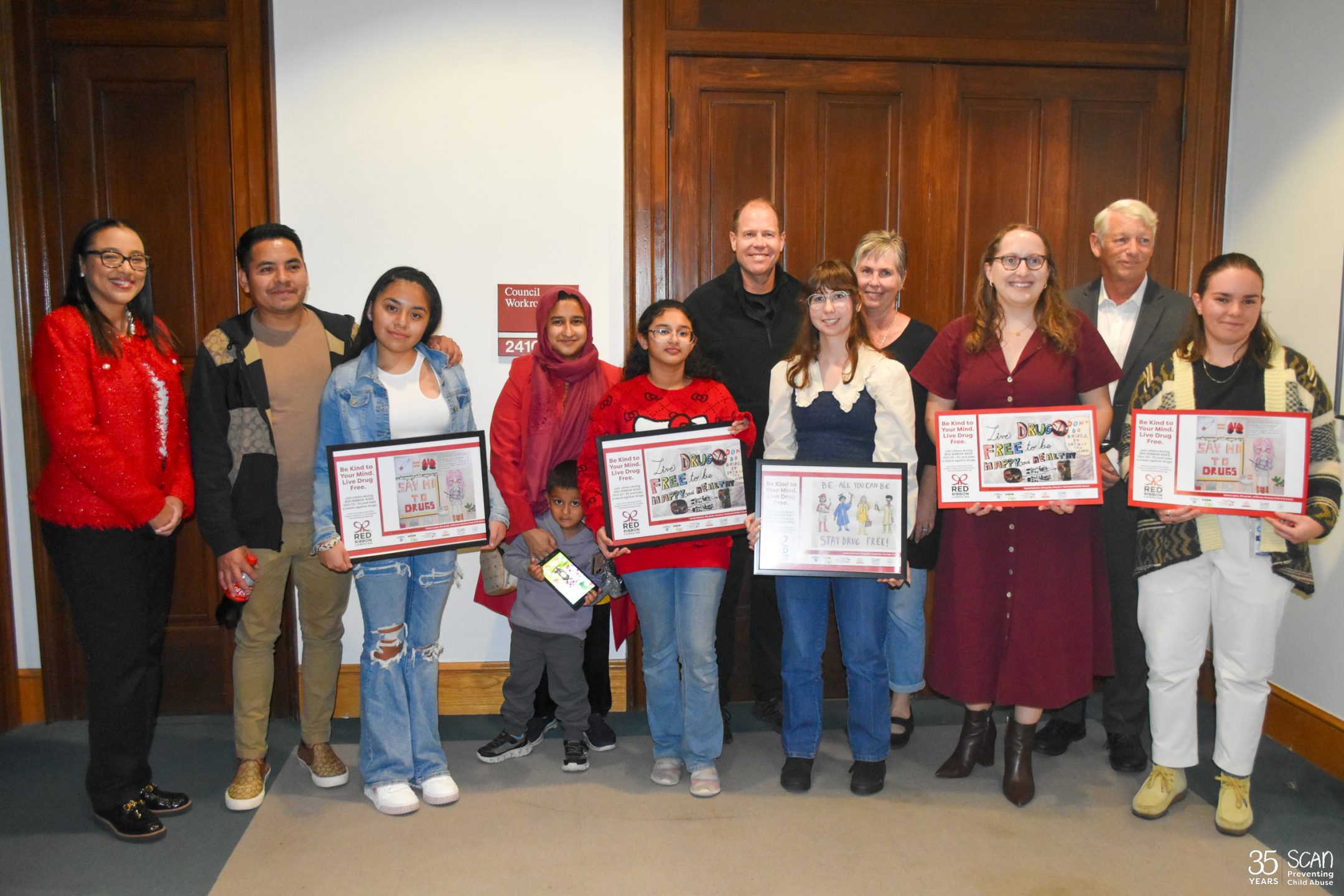 Red Ribbon Week poster winners and community advocates pose for a photo outside Alexandria City Hall